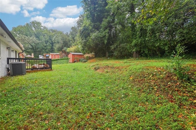 view of yard featuring an outbuilding, central AC, and a shed