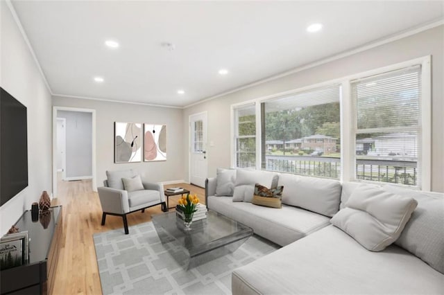 living room featuring light wood-style floors, recessed lighting, a wealth of natural light, and crown molding