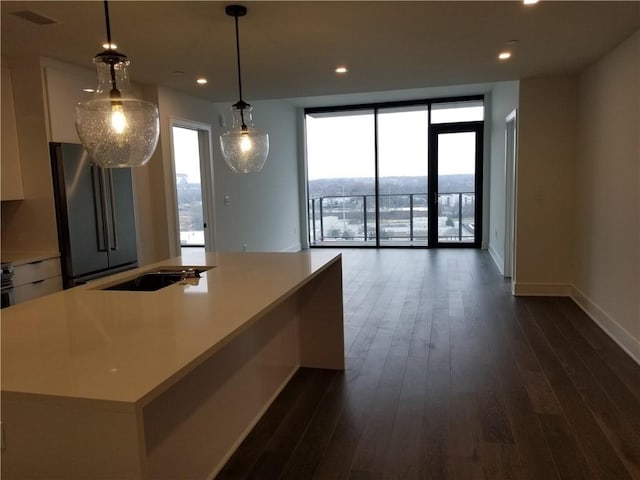 kitchen featuring a center island, dark hardwood / wood-style floors, pendant lighting, and stainless steel fridge