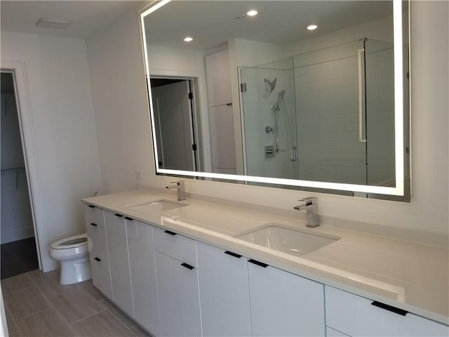 bathroom featuring an enclosed shower, vanity, and toilet