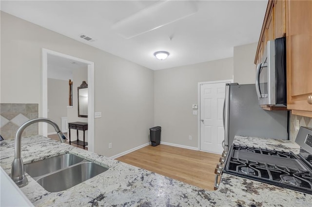 1804 Evadale Ct Unit 1, Mableton, GA 30126 - kitchen with appliances with stainless steel finishes, light wood finished floors, light stone counters, and brown cabinetry