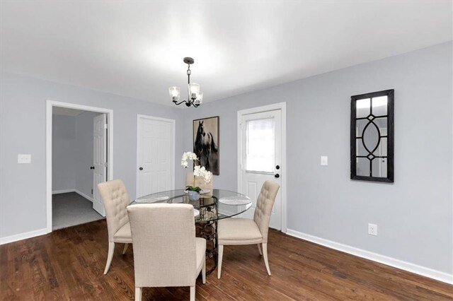 dining room with a notable chandelier and dark hardwood / wood-style flooring