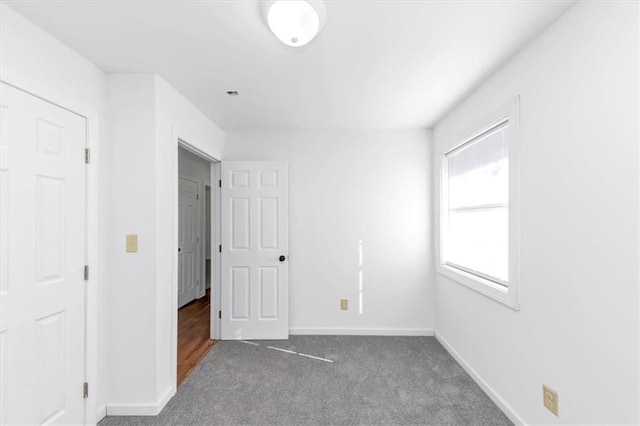 unfurnished bedroom with dark carpet