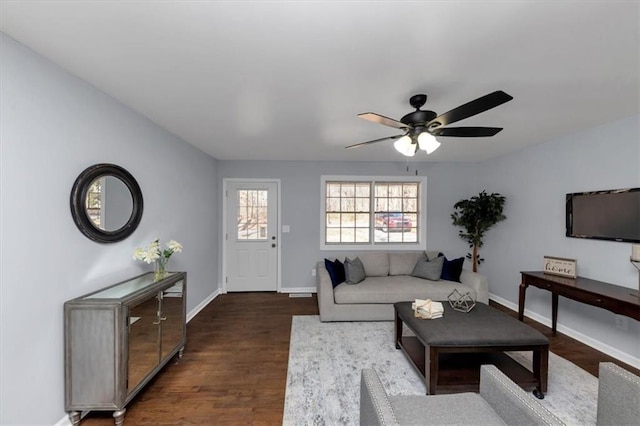 living room featuring dark wood-type flooring and ceiling fan