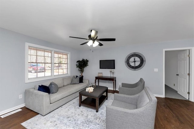 living room with ceiling fan and dark wood-type flooring