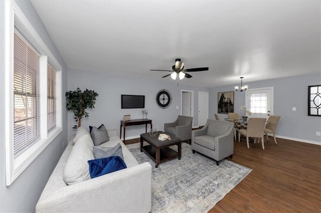 living room featuring ceiling fan with notable chandelier and dark hardwood / wood-style floors