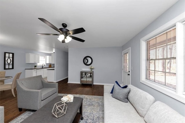 living room featuring sink, ceiling fan, a wealth of natural light, and dark hardwood / wood-style flooring