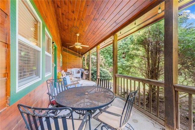 sunroom / solarium featuring wooden ceiling, vaulted ceiling, and ceiling fan