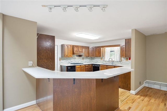 3272 Pinestream Rd NW, Atlanta, GA 30327 - kitchen featuring black appliances, a kitchen bar, a peninsula, and light wood-type flooring