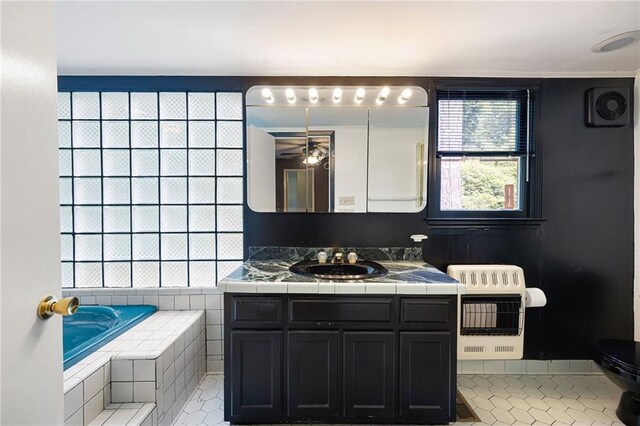 3272 Pinestream Rd NW, Atlanta, GA 30327 - bathroom featuring heating unit, ceiling fan, vanity, a relaxing tiled tub, and tile patterned floors