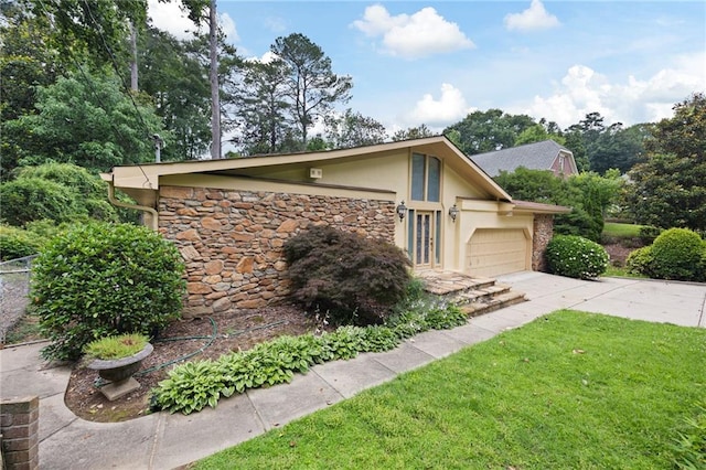 3272 Pinestream Rd NW, Atlanta, GA 30327 - view of front of house featuring stucco siding, stone siding, a garage, and driveway