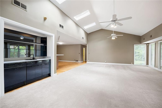 3272 Pinestream Rd NW, Atlanta, GA 30327 - unfurnished living room featuring high vaulted ceiling, light carpet, a ceiling fan, healthy amount of natural light, and a skylight