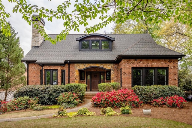 2015 N Decatur Rd NE, Atlanta, GA 30307 - tudor-style house featuring roof with shingles, brick siding, and a chimney