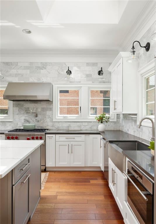 2015 N Decatur Rd NE, Atlanta, GA 30307 - kitchen with crown molding, wall chimney range hood, tasteful backsplash, and appliances with stainless steel finishes