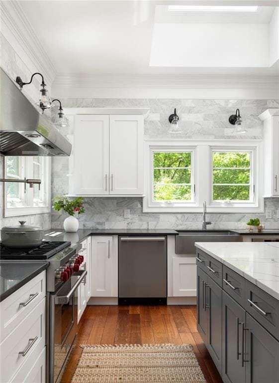 2015 N Decatur Rd NE, Atlanta, GA 30307 - kitchen with stainless steel appliances, a wealth of natural light, hardwood / wood-style flooring, and wall chimney exhaust hood