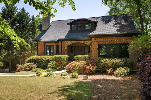 2015 N Decatur Rd NE, Atlanta, GA 30307 - view of front facade with roof with shingles, brick siding, a chimney, and a front lawn