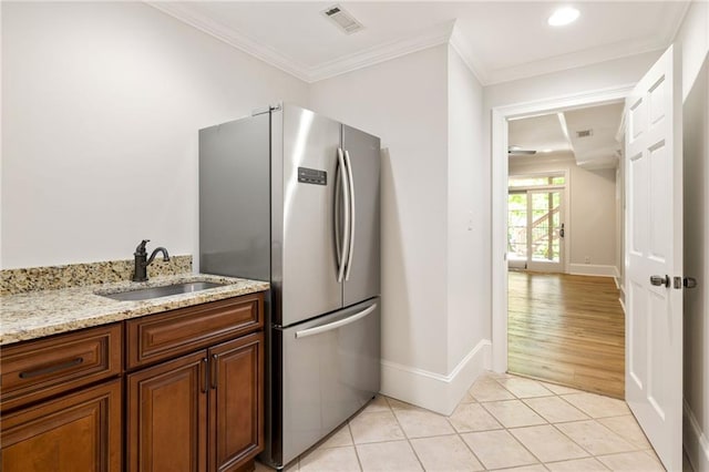 2015 N Decatur Rd NE, Atlanta, GA 30307 - kitchen featuring freestanding refrigerator, light stone countertops, visible vents, a sink, and baseboards