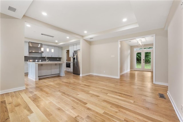 2552 Scenic Hwy S, Snellville, GA 30078 - unfurnished living room with a tray ceiling, light wood-style flooring, a sink, and recessed lighting