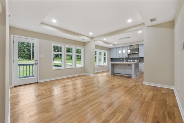 2552 Scenic Hwy S, Snellville, GA 30078 - unfurnished living room featuring baseboards, plenty of natural light, light wood-type flooring, a sink, and recessed lighting