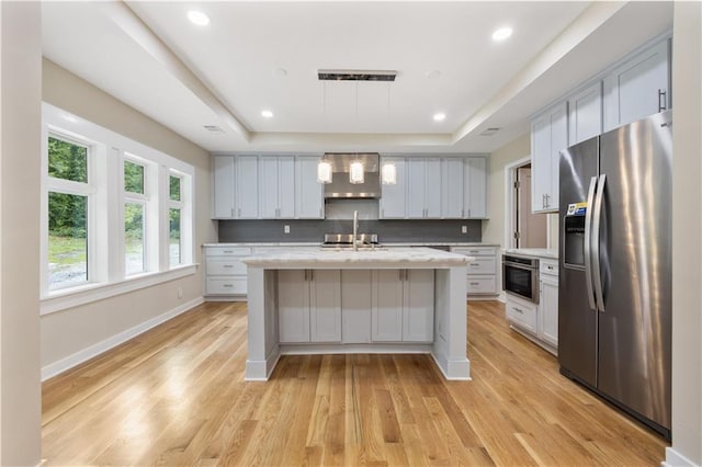 2552 Scenic Hwy S, Snellville, GA 30078 - kitchen with stainless steel appliances, wall chimney exhaust hood, a raised ceiling, tasteful backsplash, and light wood finished floors