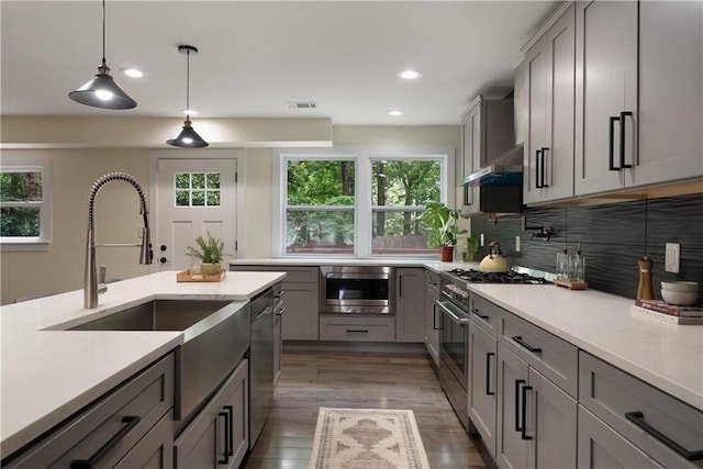 1218 Crestwood Dr SE, Atlanta, GA 30316 - kitchen with appliances with stainless steel finishes, gray cabinets, backsplash, dark wood-type flooring, and pendant lighting