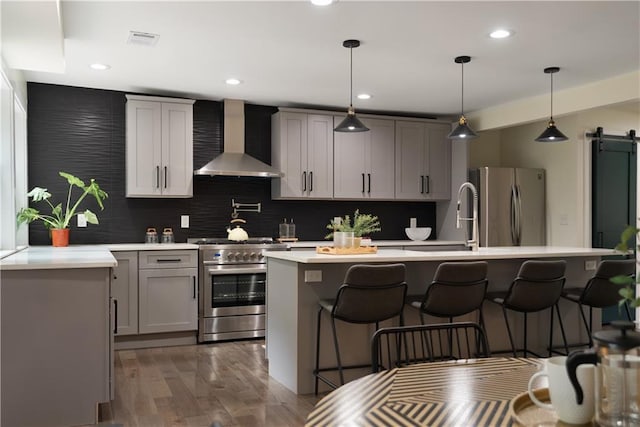 1218 Crestwood Dr SE, Atlanta, GA 30316 - kitchen featuring wall chimney exhaust hood, stainless steel appliances, a breakfast bar area, decorative backsplash, and recessed lighting