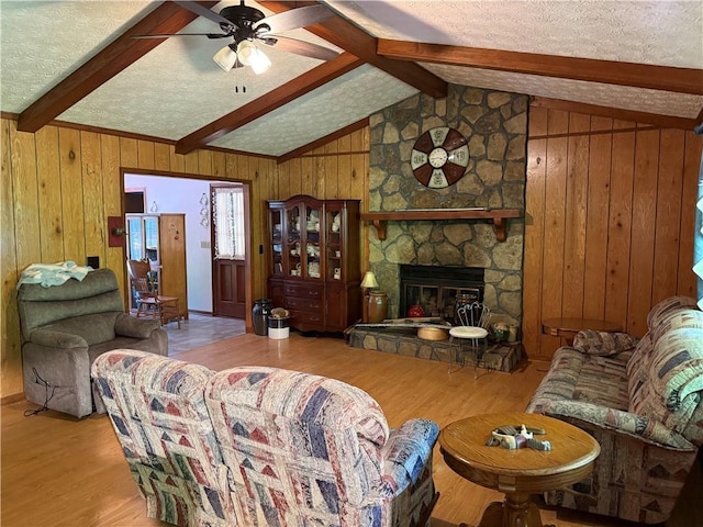 living area with vaulted ceiling with beams, ceiling fan, and wood finished floors