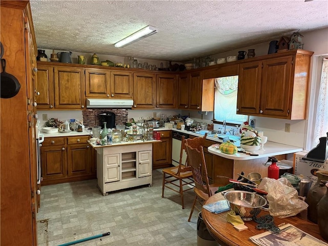 kitchen featuring under cabinet range hood, brown cabinets, light countertops, and dishwasher