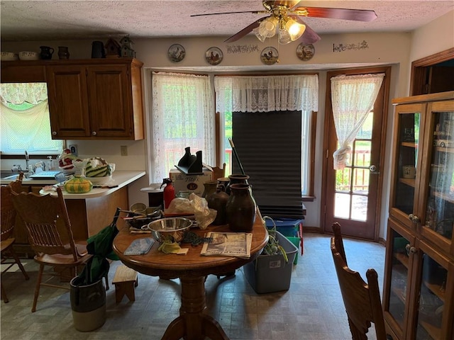 dining space featuring a textured ceiling, ceiling fan, and a healthy amount of sunlight