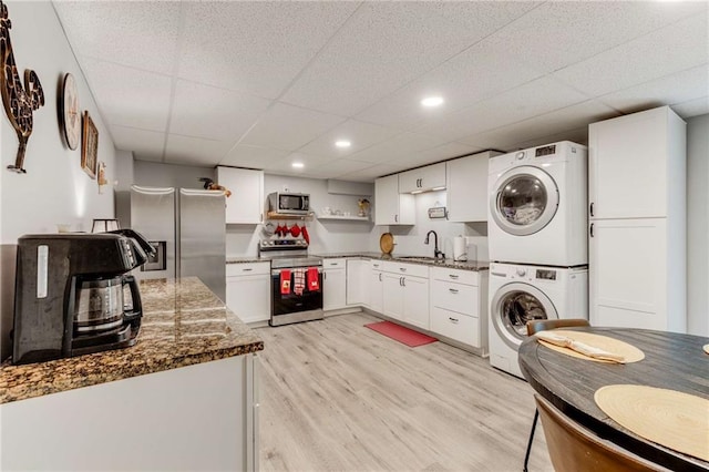 99 Bree Ln, Canton, GA 30114 - kitchen with open shelves, a paneled ceiling, a sink, appliances with stainless steel finishes, and stacked washer / drying machine