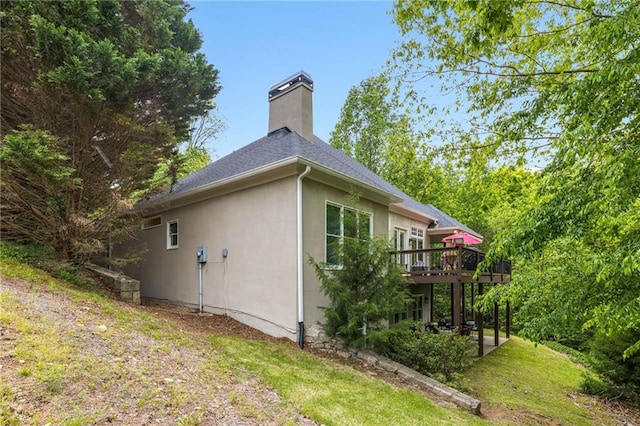 99 Bree Ln, Canton, GA 30114 - view of side of home featuring a chimney, roof with shingles, stucco siding, and a deck