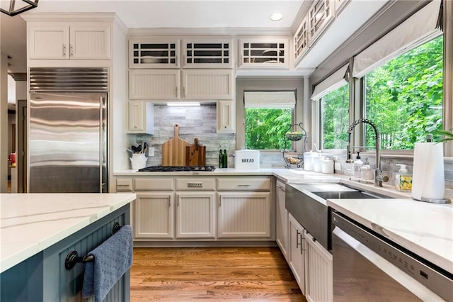 99 Bree Ln, Canton, GA 30114 - kitchen with decorative backsplash, a sink, light stone counters, light wood finished floors, and stainless steel appliances