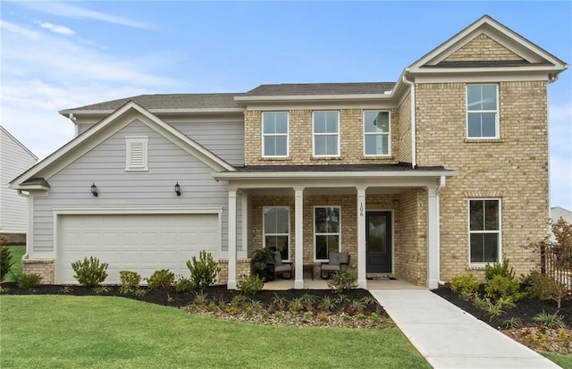 view of front facade with a garage, covered porch, and a front lawn