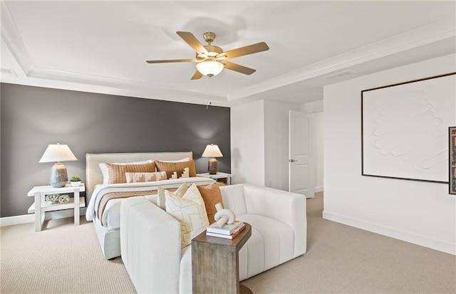 carpeted bedroom with ceiling fan and a raised ceiling