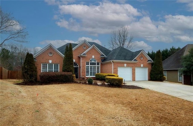 traditional home with a front yard, fence, driveway, an attached garage, and brick siding