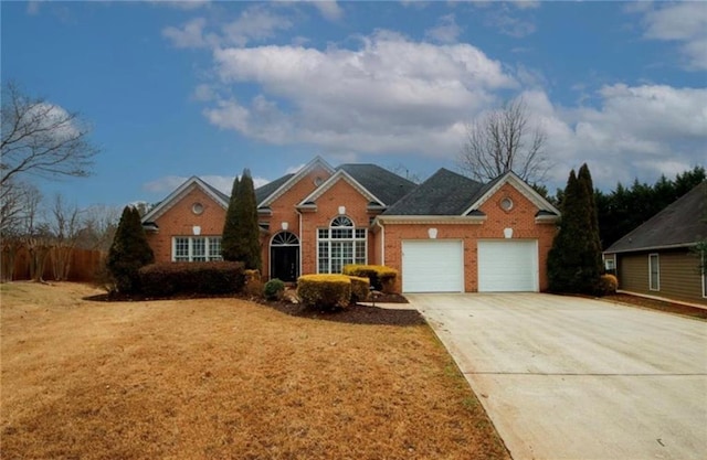 traditional-style house featuring brick siding, an attached garage, driveway, and a front lawn