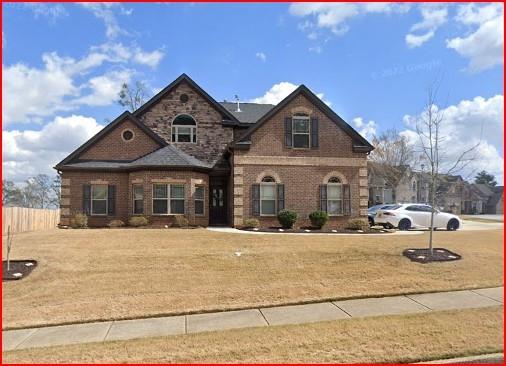 traditional home with a front yard and brick siding