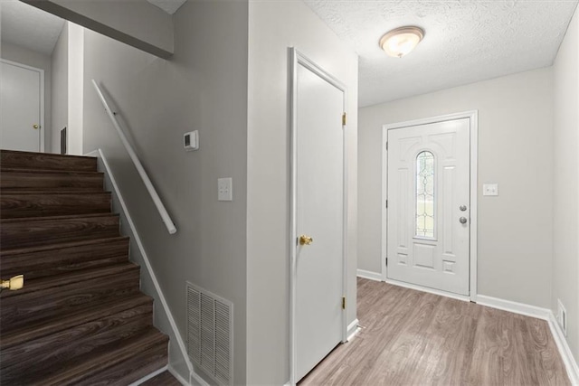 foyer entrance featuring hardwood / wood-style flooring and a textured ceiling