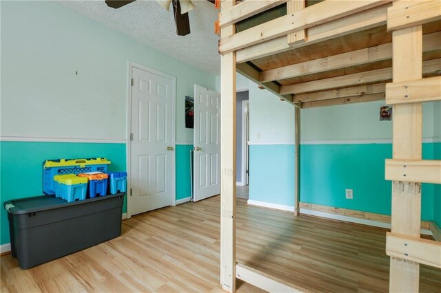 basement featuring ceiling fan, wood finished floors, and baseboards