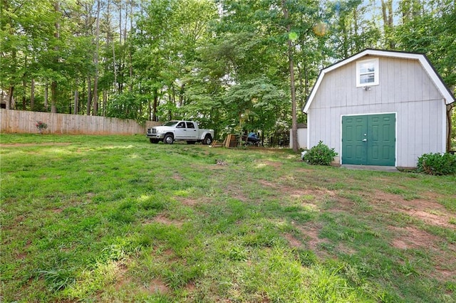 view of yard with an outbuilding and view of wooded area