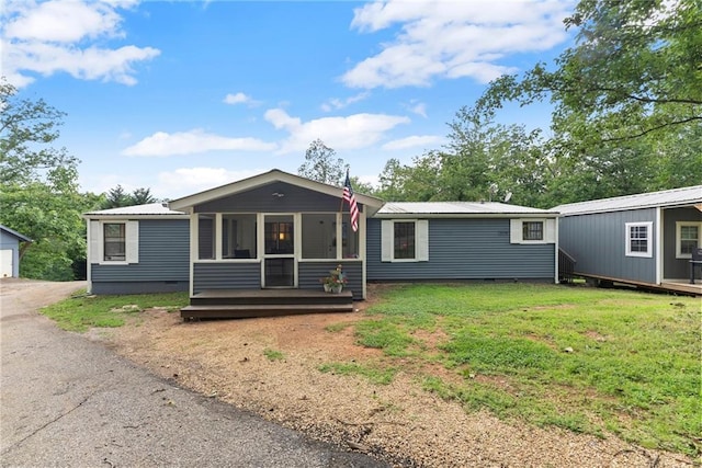 282 Hugh Stowers Rd, Dawsonville, GA 30534 - view of front of property with an outbuilding, a metal roof, a front yard, and a sunroom