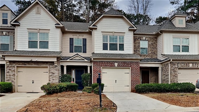 multi unit property with brick siding, driveway, a garage, and roof with shingles