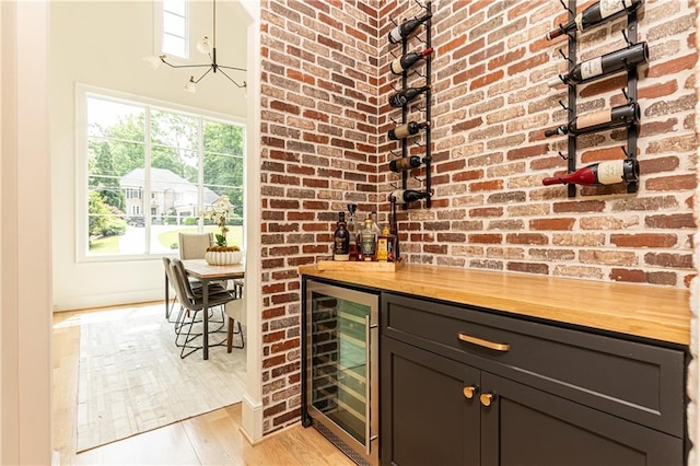 3338 Breton Cir NE, Brookhaven, GA 30319 - indoor dry bar with wine cooler, light wood-style flooring, and brick wall