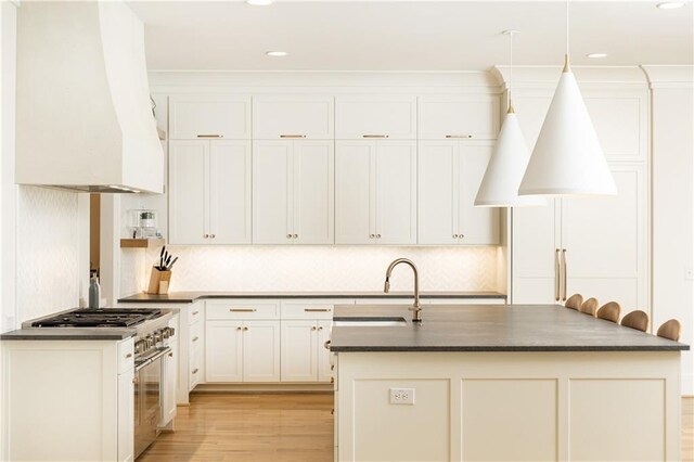 3338 Breton Cir NE, Brookhaven, GA 30319 - kitchen featuring custom exhaust hood, a sink, light wood-style flooring, an island with sink, and decorative backsplash