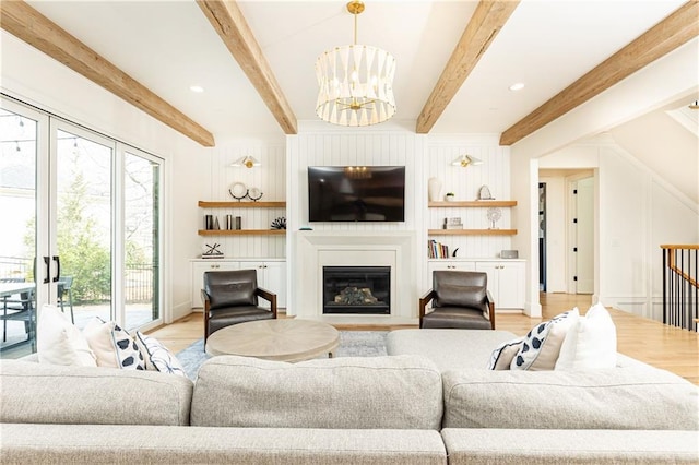 3338 Breton Cir NE, Brookhaven, GA 30319 - living area with a chandelier, light wood finished floors, a glass covered fireplace, beamed ceiling, and built in shelves