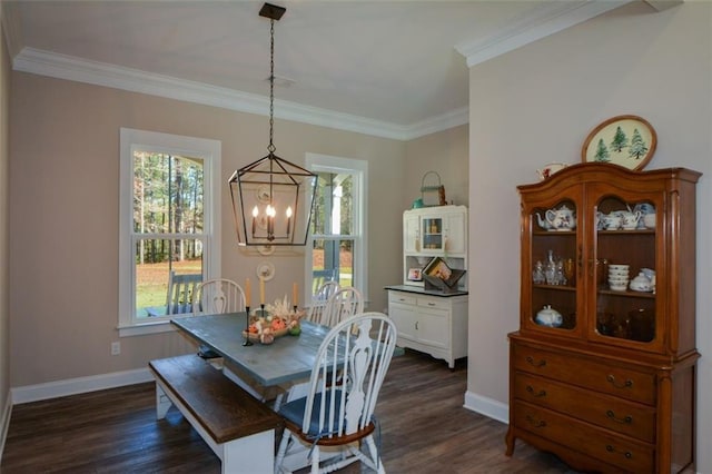 dining area featuring dark hardwood / wood-style flooring, a wealth of natural light, ornamental molding, and a notable chandelier