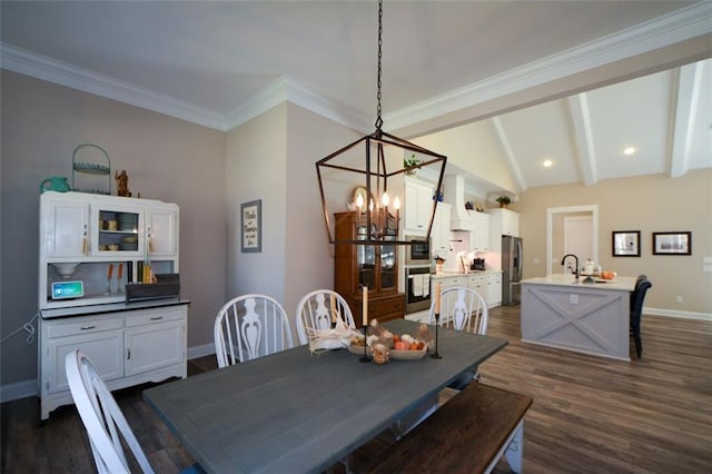 dining area featuring sink, lofted ceiling with beams, dark hardwood / wood-style floors, and ornamental molding