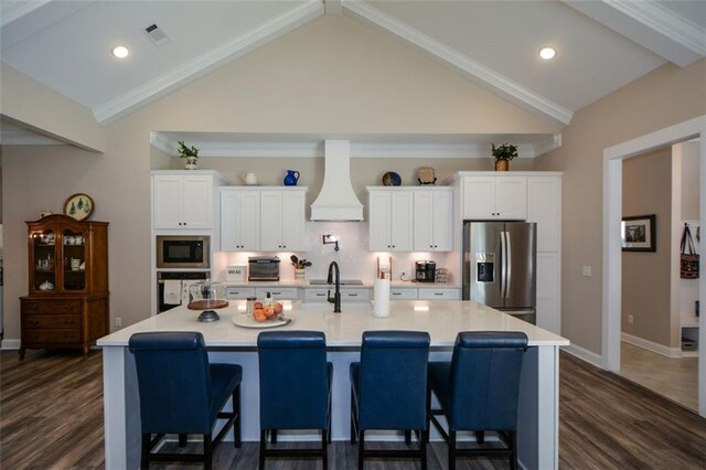 kitchen with a spacious island, custom range hood, and appliances with stainless steel finishes