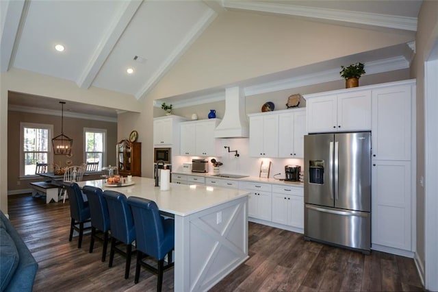 kitchen with white cabinetry, dark hardwood / wood-style floors, premium range hood, stainless steel fridge, and an island with sink