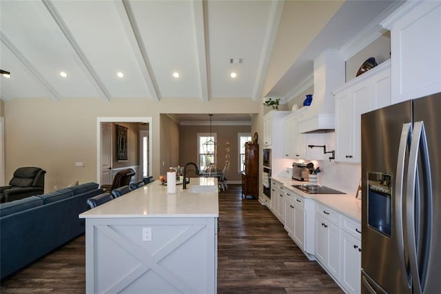 kitchen featuring white cabinets, stainless steel fridge, lofted ceiling with beams, and sink